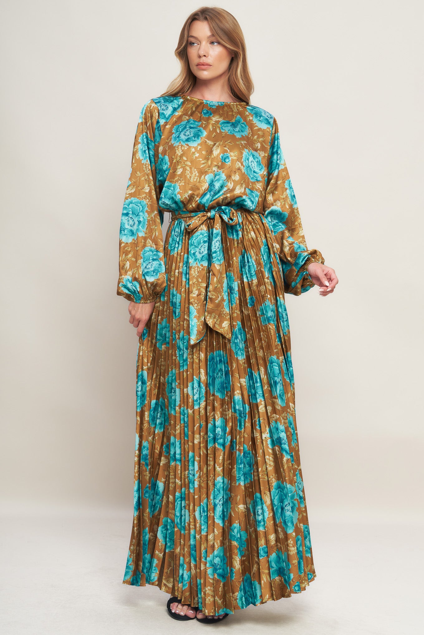 A printed woven satin maxi dress featuring round neckline, long sleeve, elasticized waist with pleated skirt and back button closure