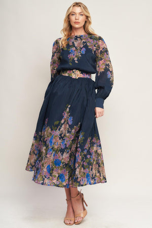 A printed woven midi dress featuring round neckline, long sleeve with wide cuff, waist band, full skirt and back zipper closure