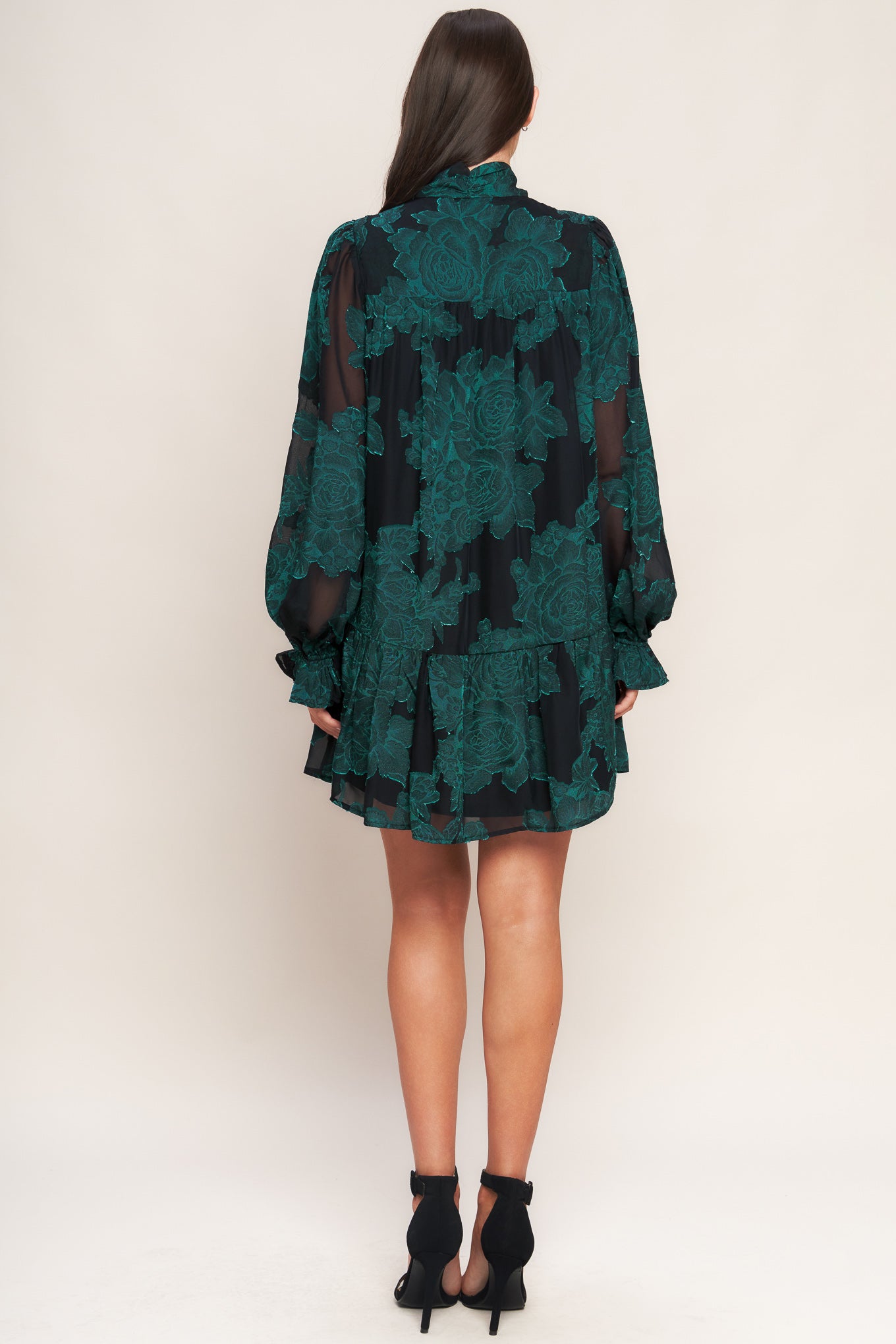 A burnout woven mini dress featuring front tie, long sleeve with ruffled cuff and ruffled hemline