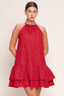A textured woven mini dress featuring halter neckline with jewel embellishment, double ruffled hem and back neck button closure