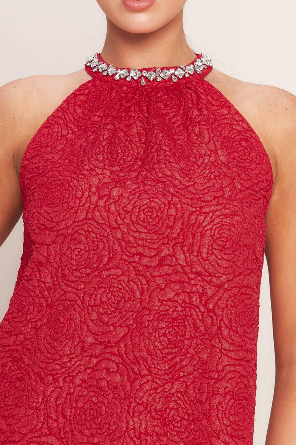 A textured woven mini dress featuring halter neckline with jewel embellishment, double ruffled hem and back neck button closure