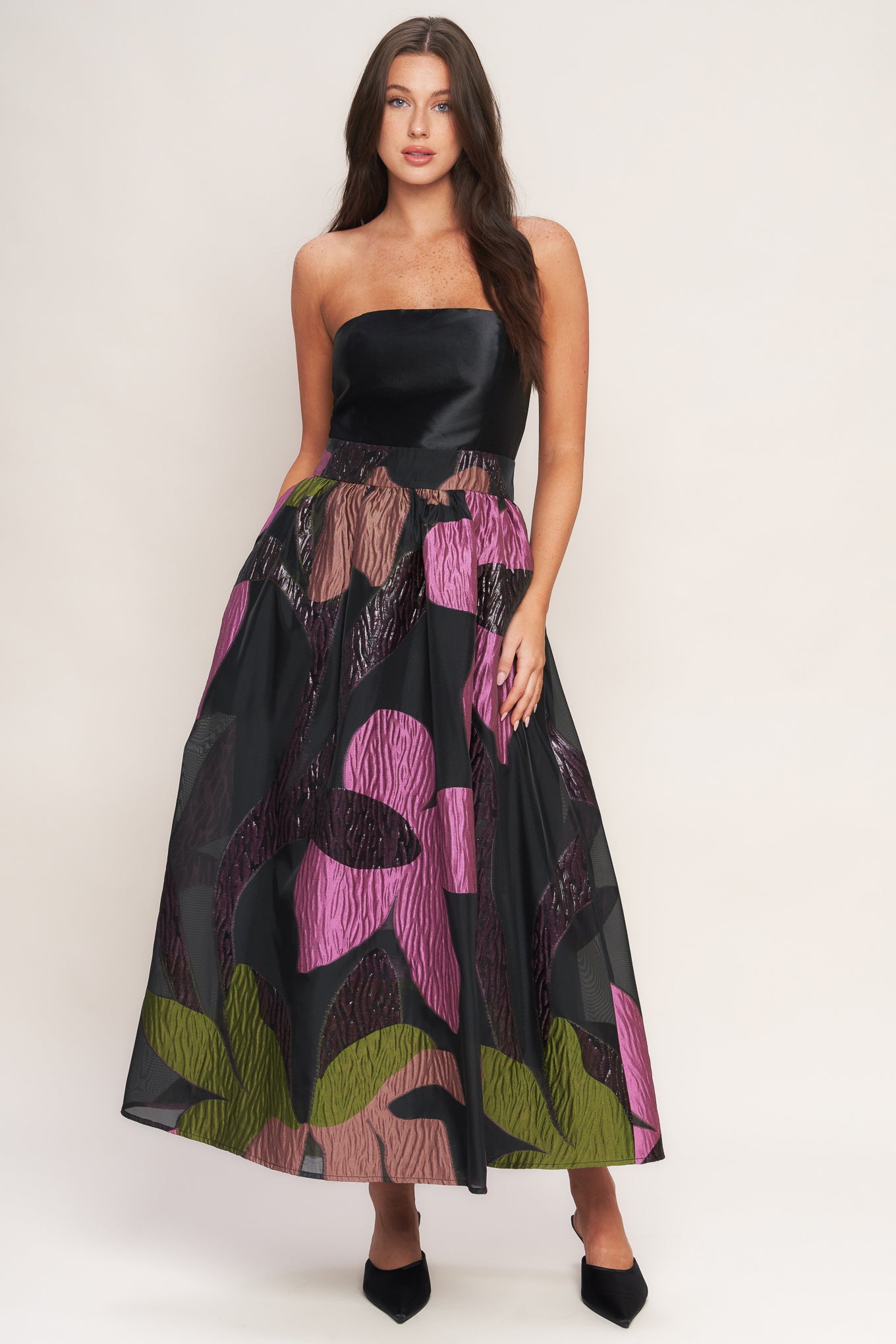A solid and printed woven midi dress featuring solid tube top, printed full skirt and back zipper closure