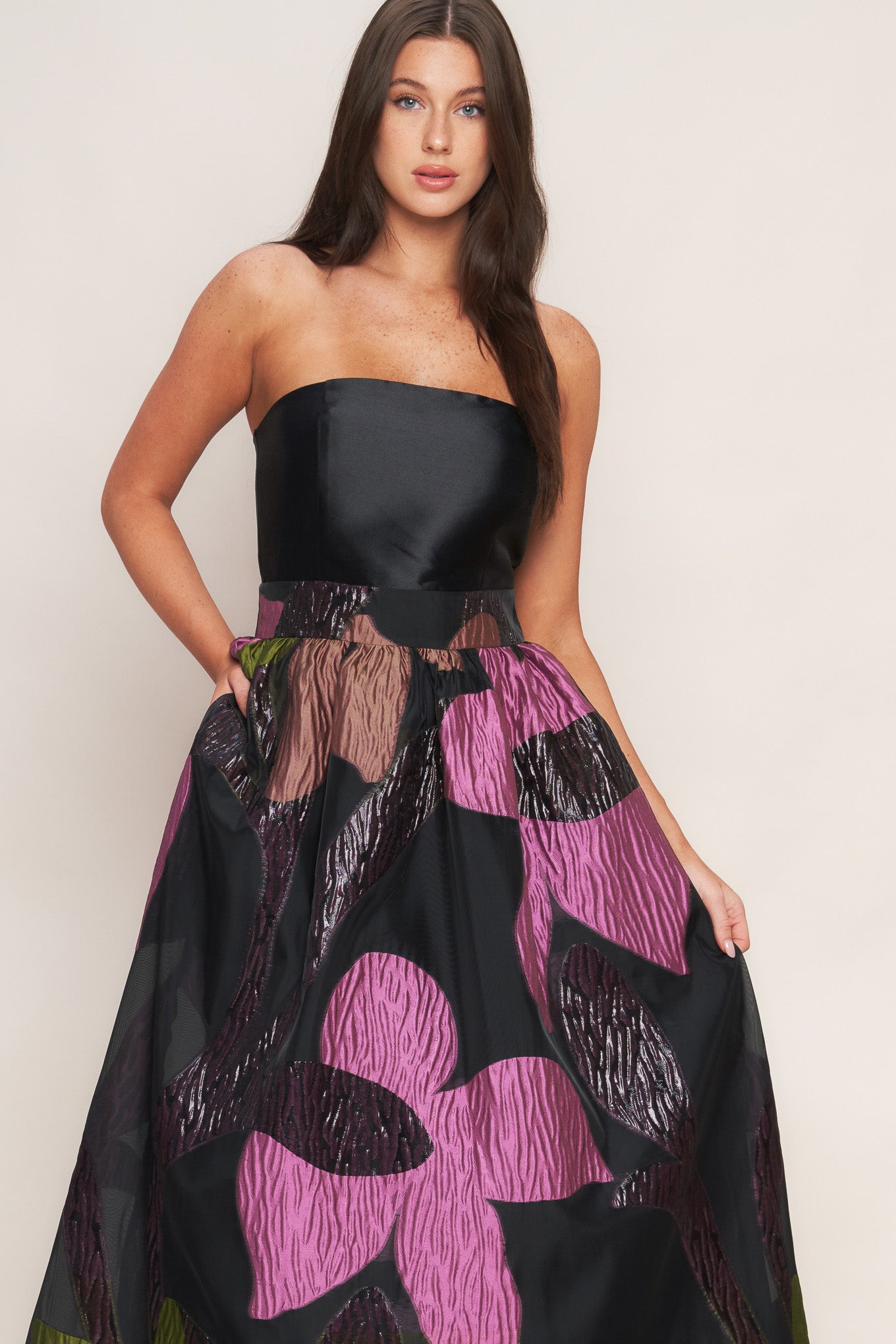 A solid and printed woven midi dress featuring solid tube top, printed full skirt and back zipper closure