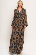 A woven jacquard maxi dress featuring surplice neckline, long sleeve, elasticized waist with self sash and ruffled hemline