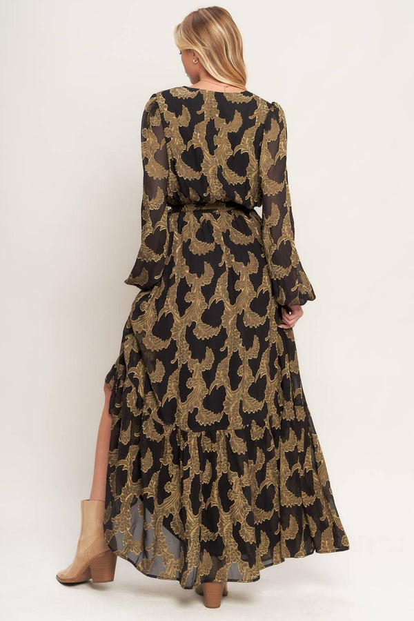 A woven jacquard maxi dress featuring surplice neckline, long sleeve, elasticized waist with self sash and ruffled hemline