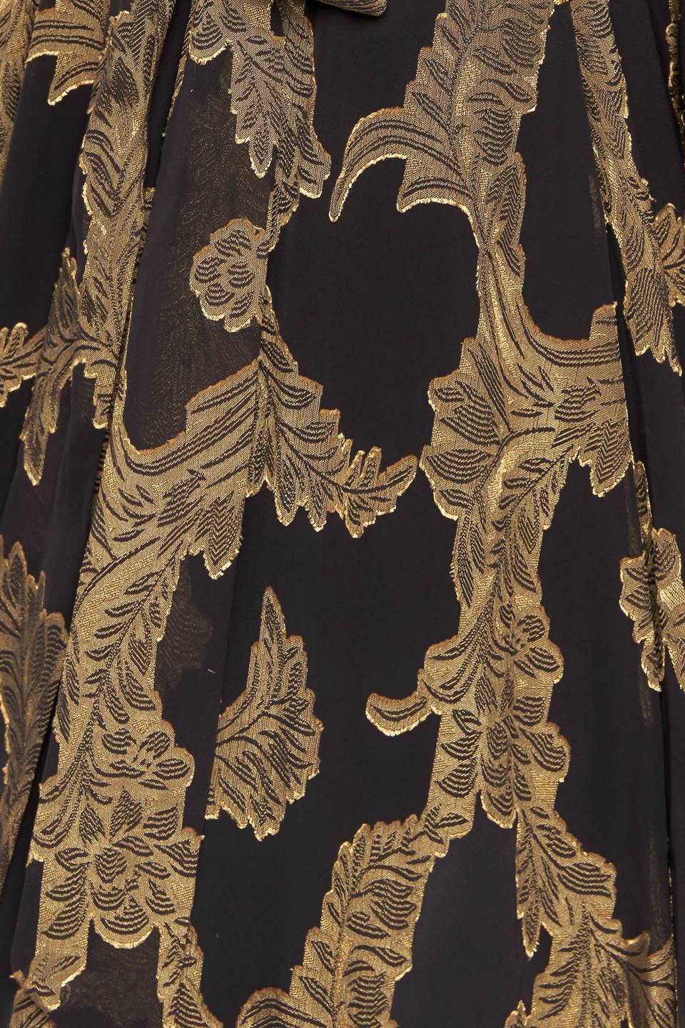 A woven jacquard maxi dress featuring surplice neckline, long sleeve, elasticized waist with self sash and ruffled hemline