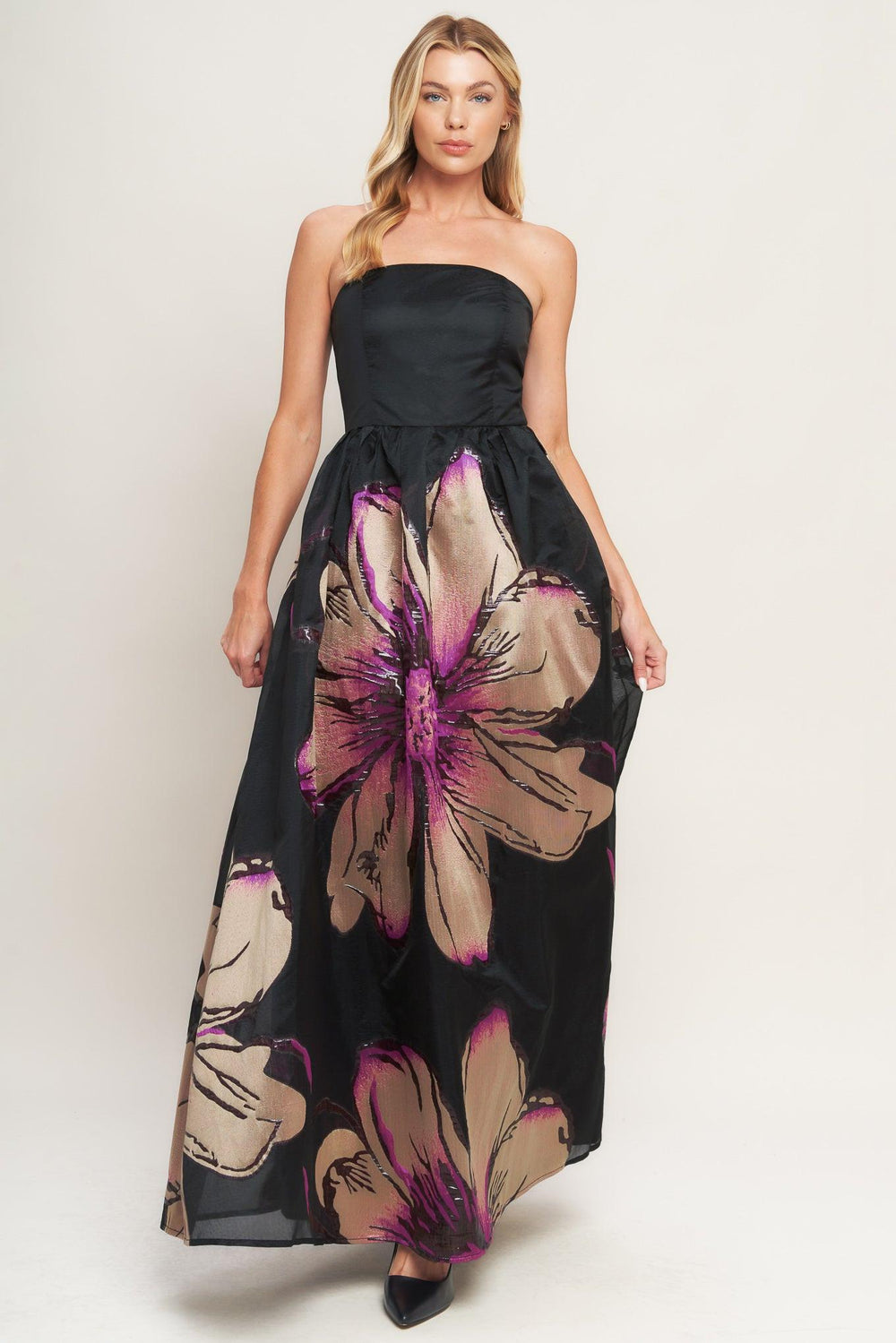 A solid and printed woven maxi dress featuring solid tube top, printed full skirt and back zipper closure