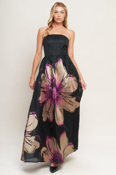 A solid and printed woven maxi dress featuring solid tube top, printed full skirt and back zipper closure