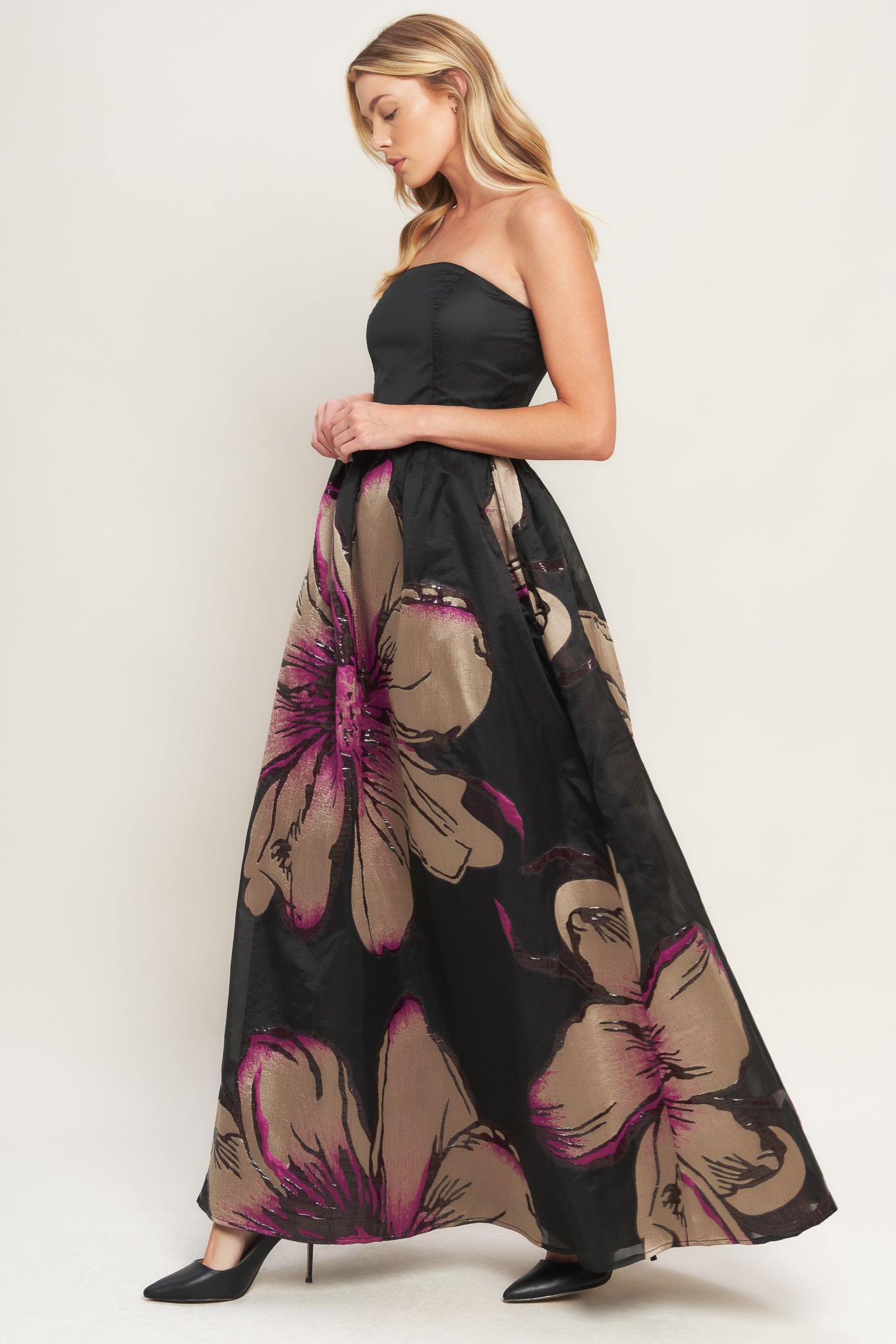 A solid and printed woven maxi dress featuring solid tube top, printed full skirt and back zipper closure