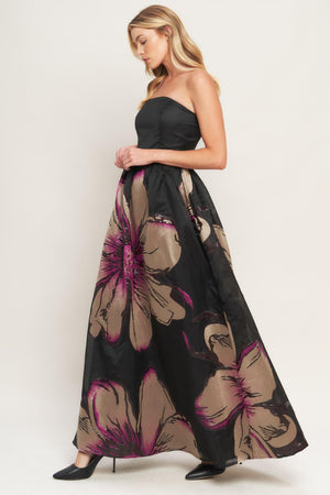 A solid and printed woven maxi dress featuring solid tube top, printed full skirt and back zipper closure
