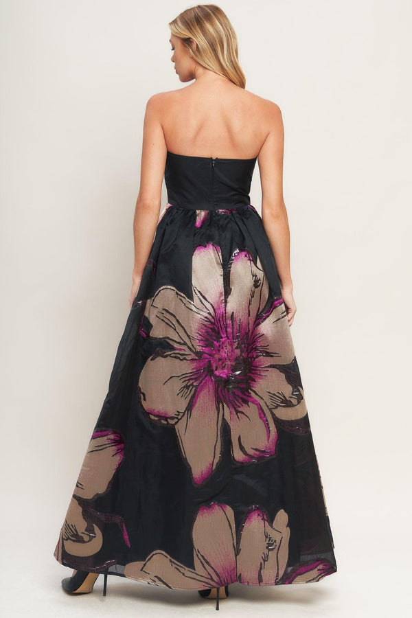 A solid and printed woven maxi dress featuring solid tube top, printed full skirt and back zipper closure