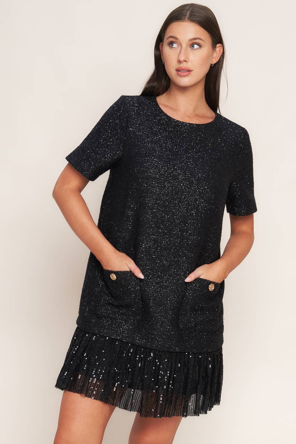 A tweed mini dress featuring round neckline, short sleeve, front pocket, sequined ruffle hem and back zipper closure