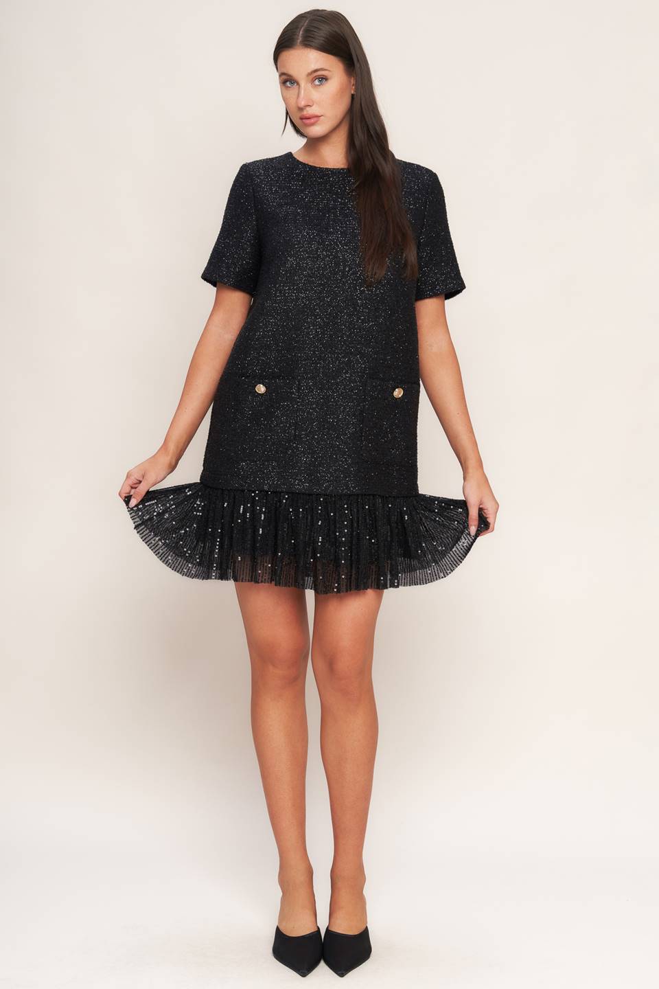 A tweed mini dress featuring round neckline, short sleeve, front pocket, sequined ruffle hem and back zipper closure