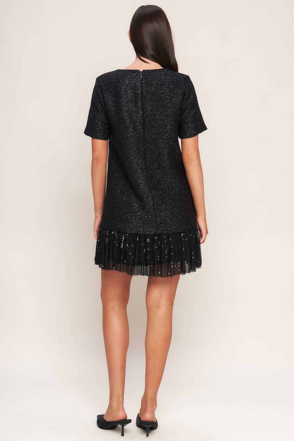 A tweed mini dress featuring round neckline, short sleeve, front pocket, sequined ruffle hem and back zipper closure