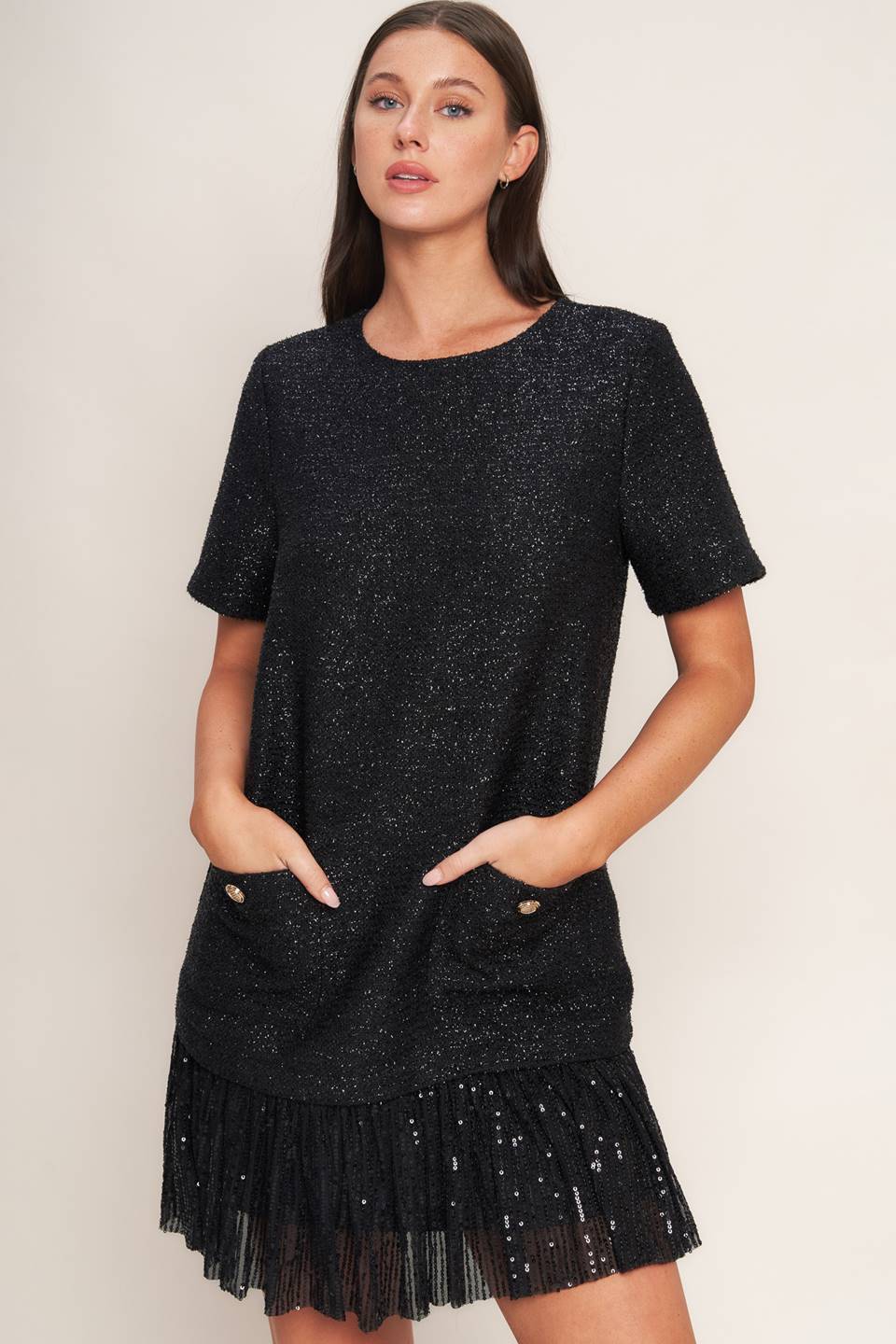 A tweed mini dress featuring round neckline, short sleeve, front pocket, sequined ruffle hem and back zipper closure