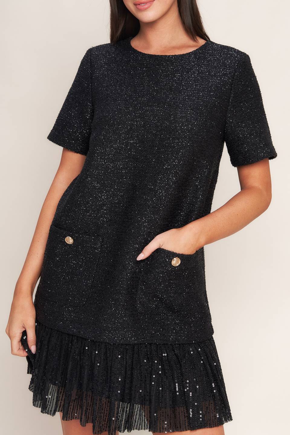 A tweed mini dress featuring round neckline, short sleeve, front pocket, sequined ruffle hem and back zipper closure