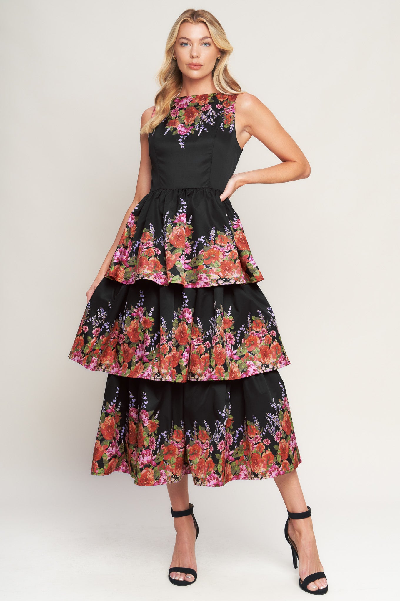 A printed woven midi dress featuring wide neckline, sleeveless, layered skirt and back zipper closure