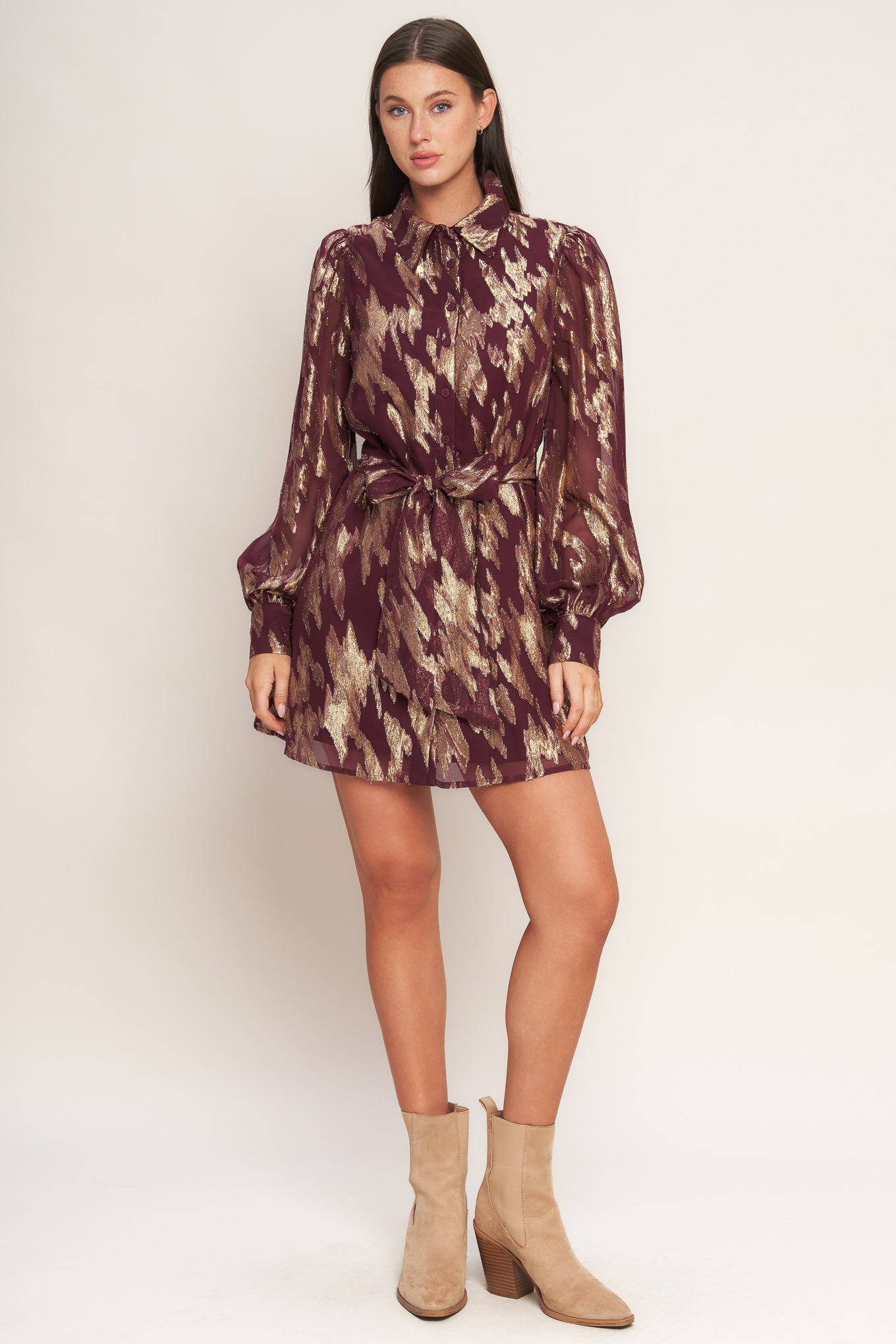 A metallic threaded woven mini dress featuring collar, bow tie, front button down and long sleeve with cuff