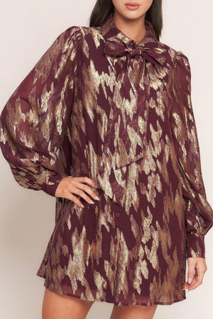A metallic threaded woven mini dress featuring collar, bow tie, front button down and long sleeve with cuff