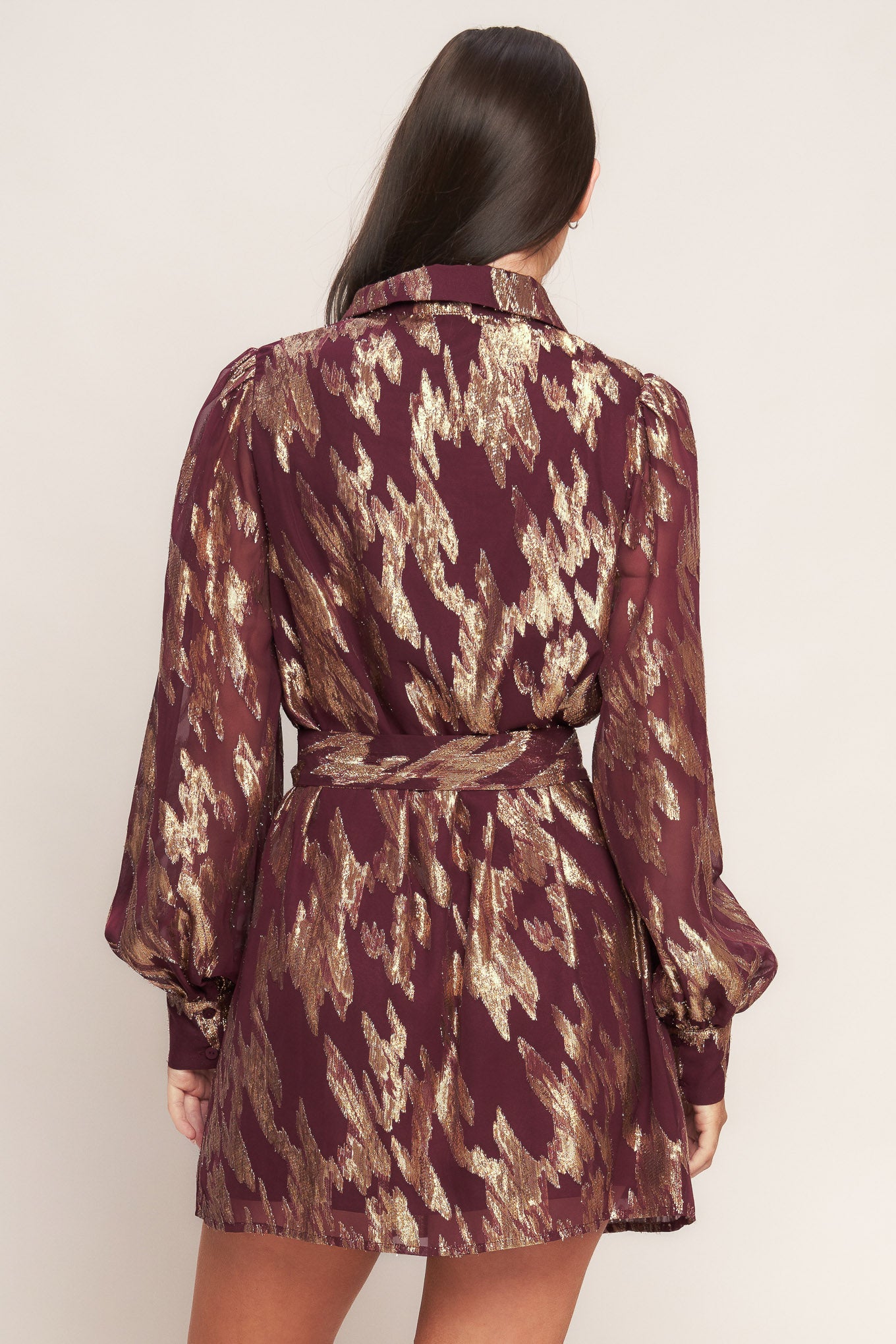 A metallic threaded woven mini dress featuring collar, bow tie, front button down and long sleeve with cuff