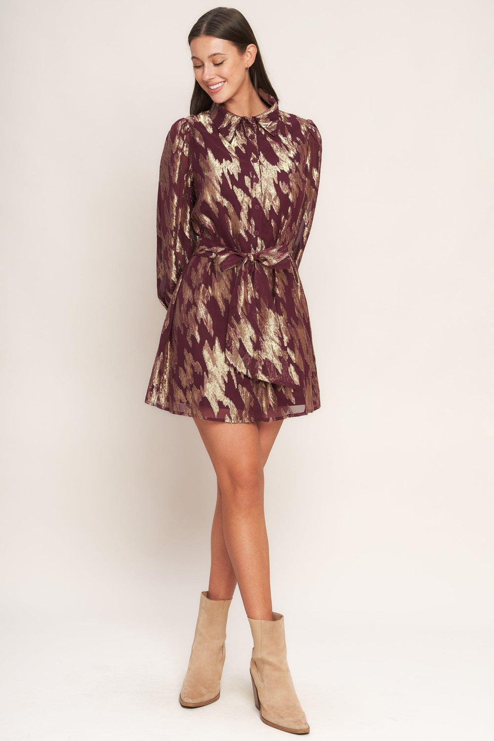 A metallic threaded woven mini dress featuring collar, bow tie, front button down and long sleeve with cuff
