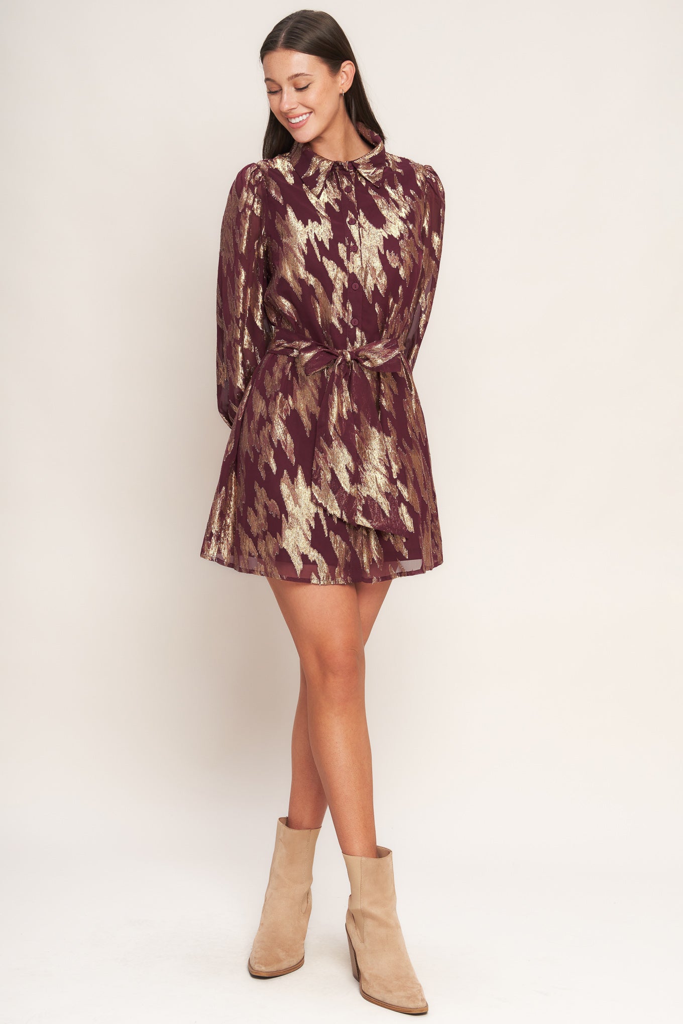 A metallic threaded woven mini dress featuring collar, bow tie, front button down and long sleeve with cuff