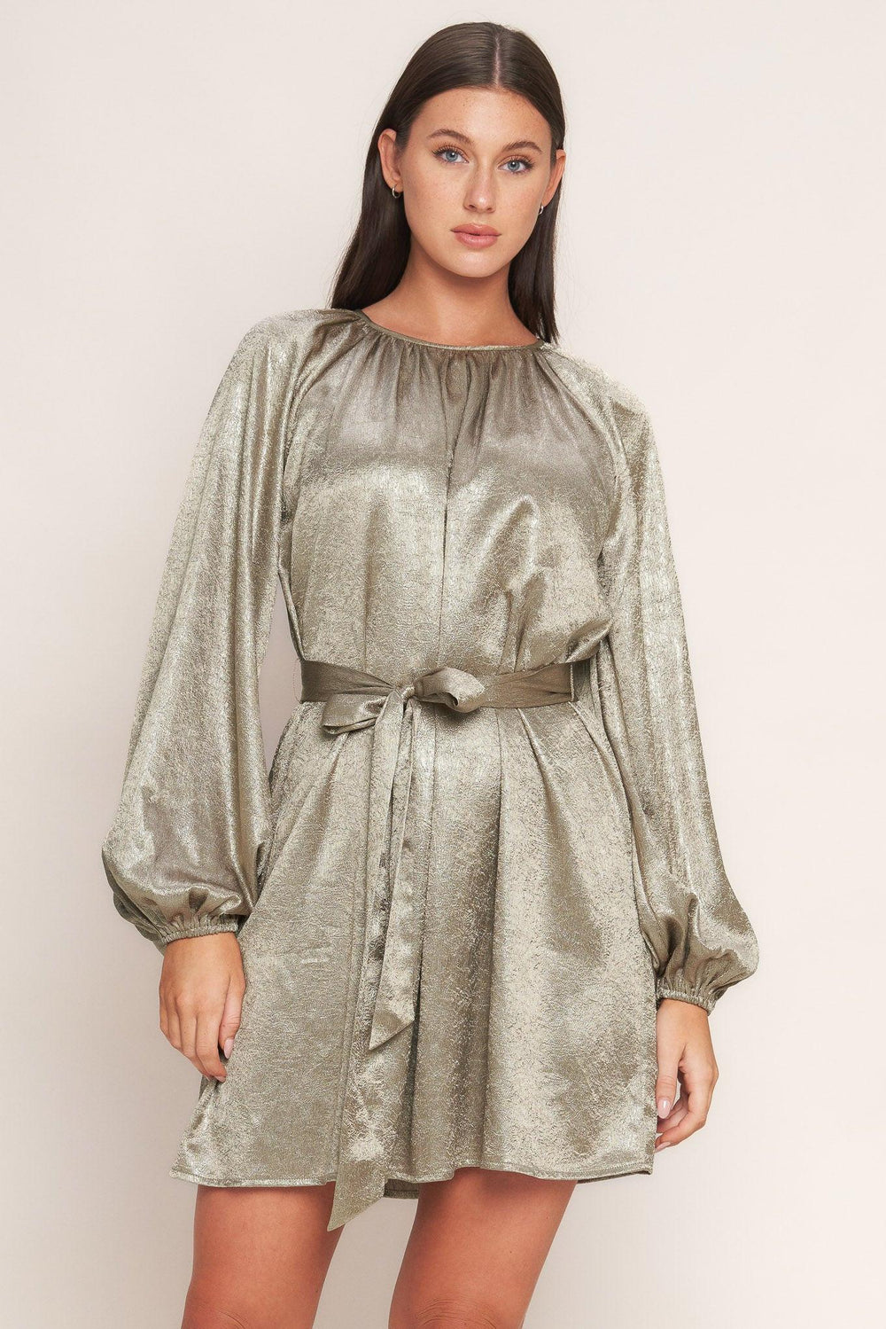 A foiled woven mini dress featuring round neckline, long sleeve, self sash tie and back neck button closure