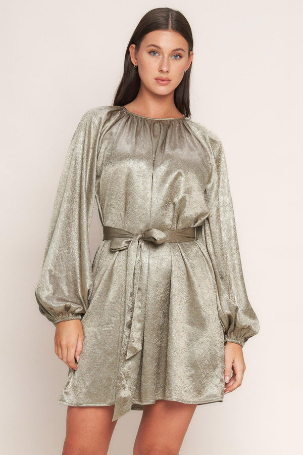 A foiled woven mini dress featuring round neckline, long sleeve, self sash tie and back neck button closure