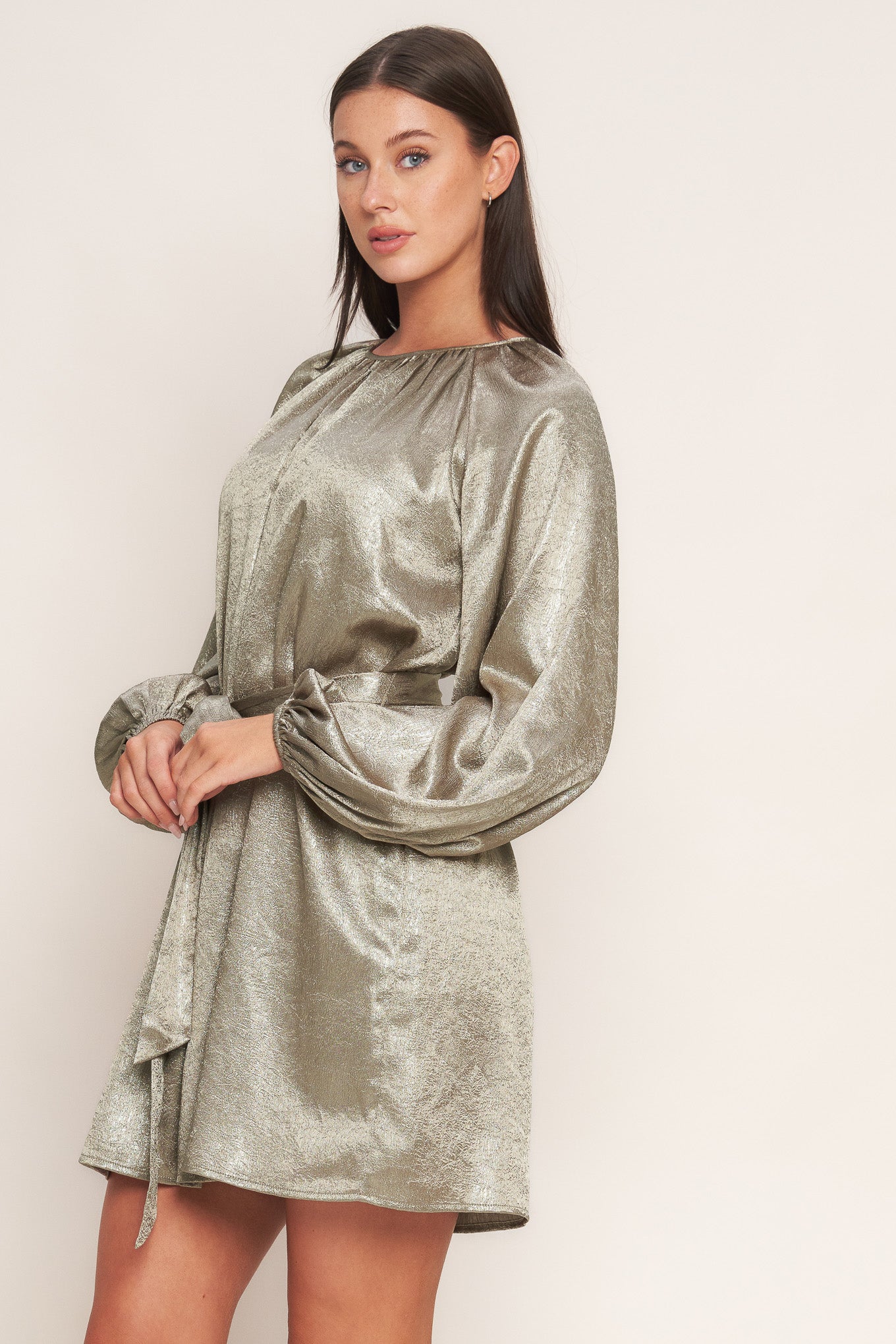 A foiled woven mini dress featuring round neckline, long sleeve, self sash tie and back neck button closure
