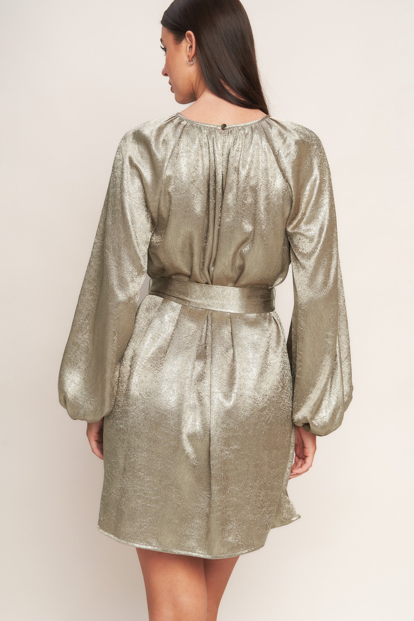 A foiled woven mini dress featuring round neckline, long sleeve, self sash tie and back neck button closure
