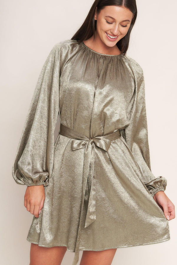 A foiled woven mini dress featuring round neckline, long sleeve, self sash tie and back neck button closure
