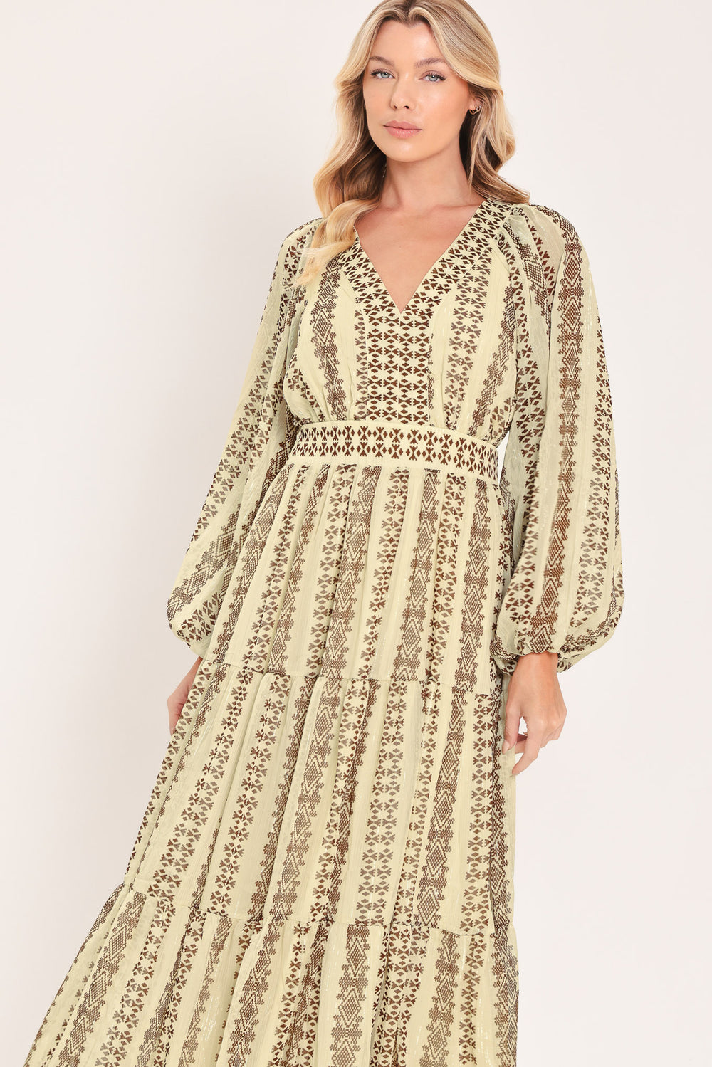 A woman modeling a long-sleeve midi dress with a beige and brown geometric pattern | Flying Tomato