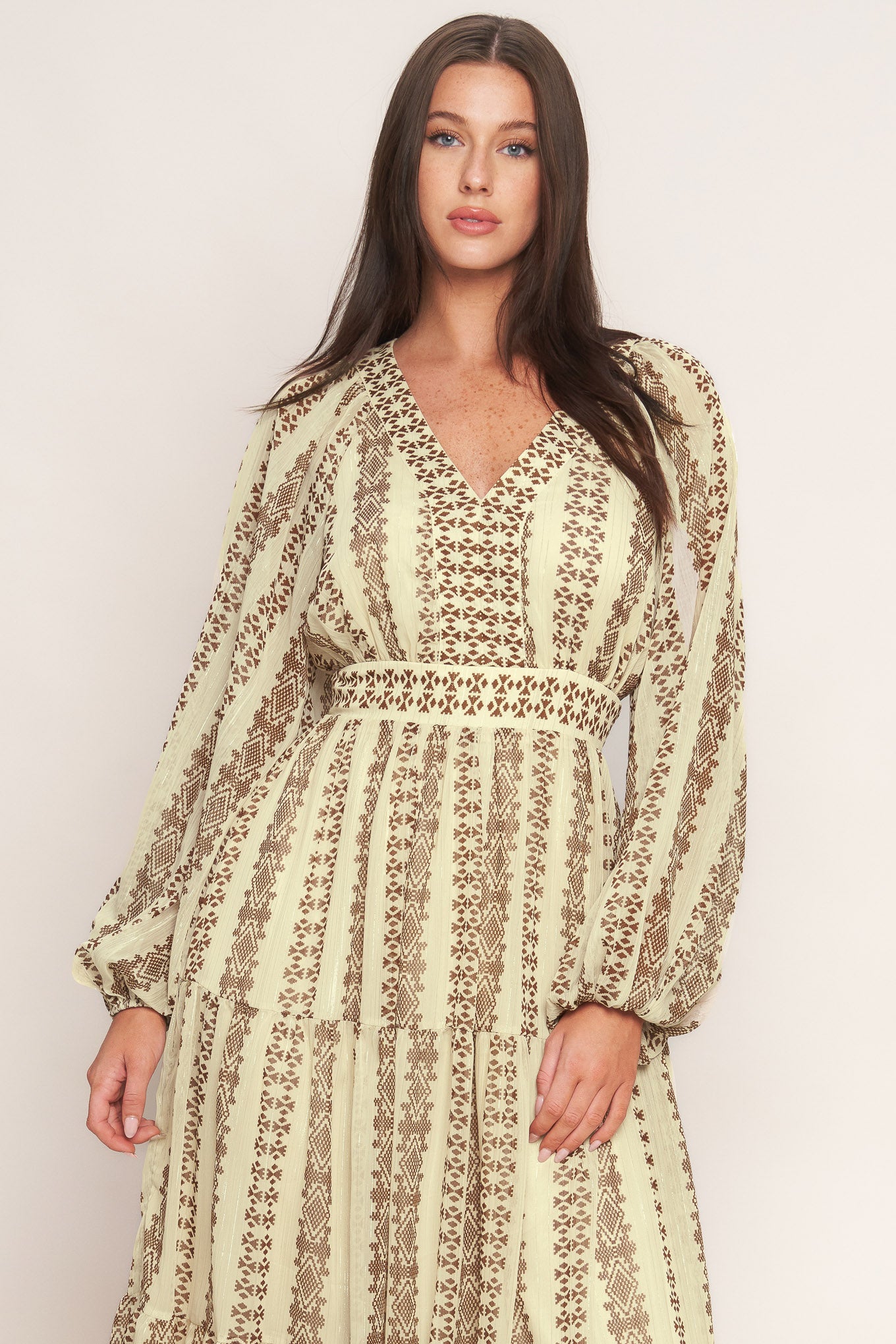 A printed metallic threaded woven midi dress featuring V neckline, long sleeve, tiered skirt and smocked back waist band