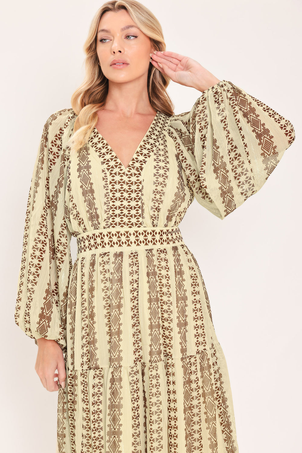 A woman modeling a long-sleeve midi dress with a beige and brown geometric pattern | Flying Tomato
