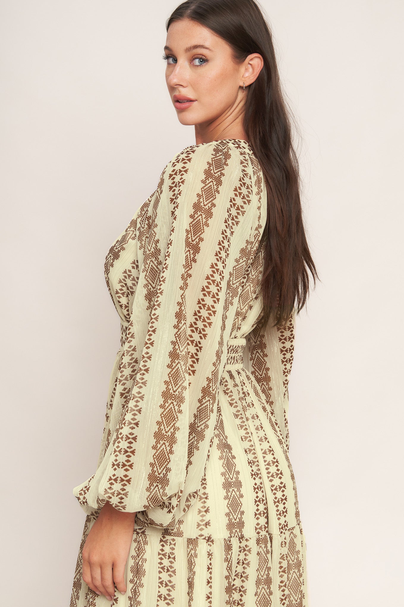 A printed metallic threaded woven midi dress featuring V neckline, long sleeve, tiered skirt and smocked back waist band