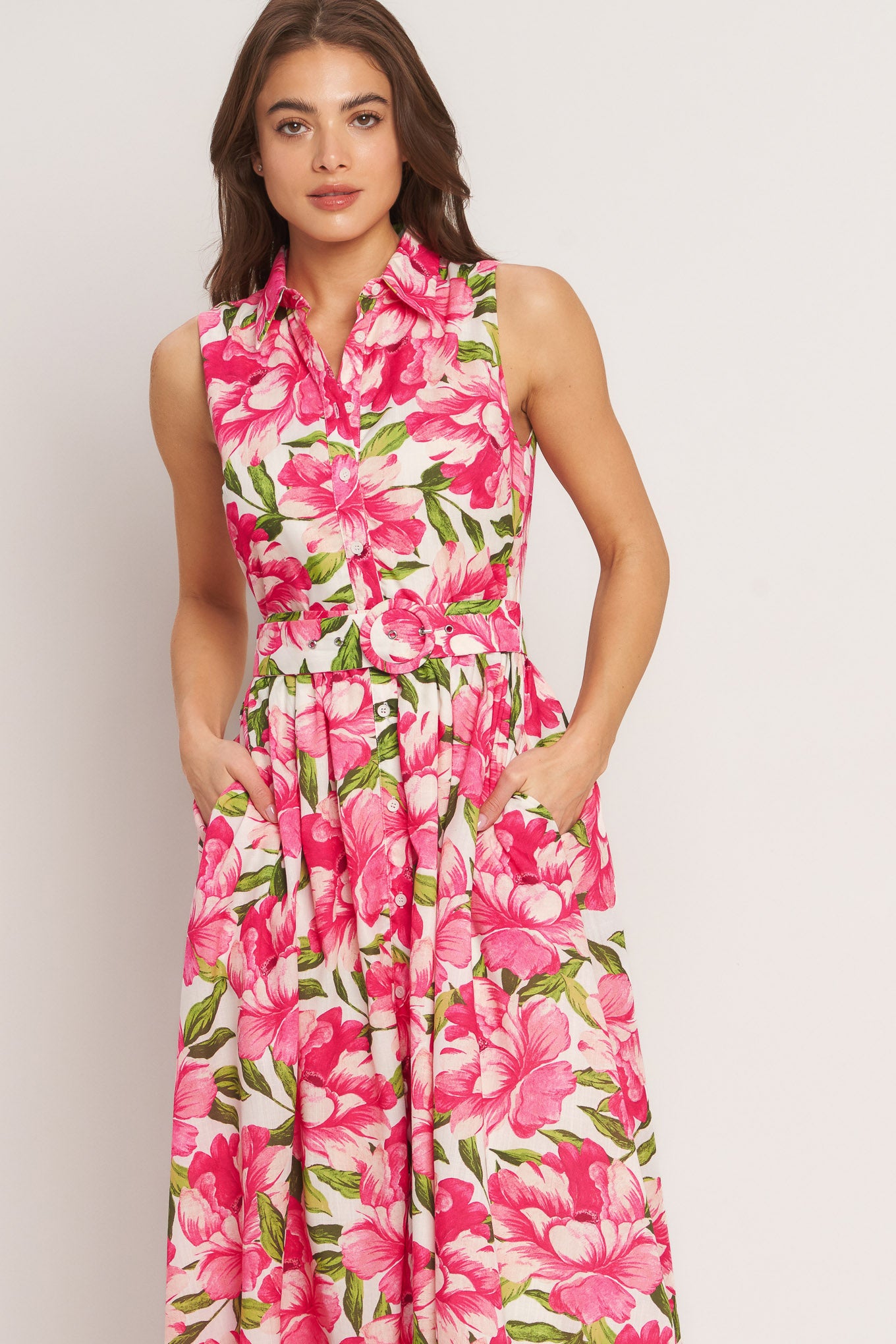 A printed woven midi dress featuring collar, sleeveless, front button down, self belt and full skirt