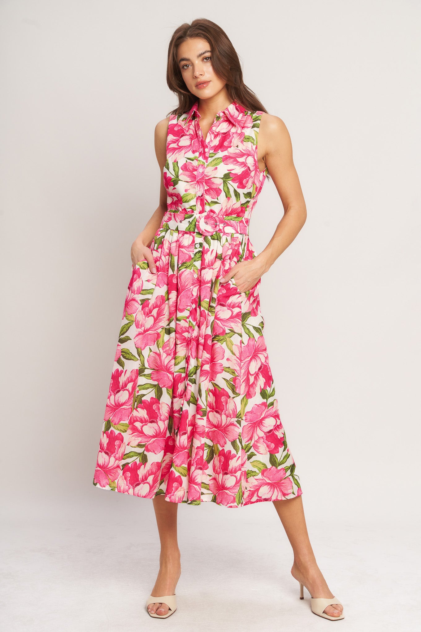 A printed woven midi dress featuring collar, sleeveless, front button down, self belt and full skirt