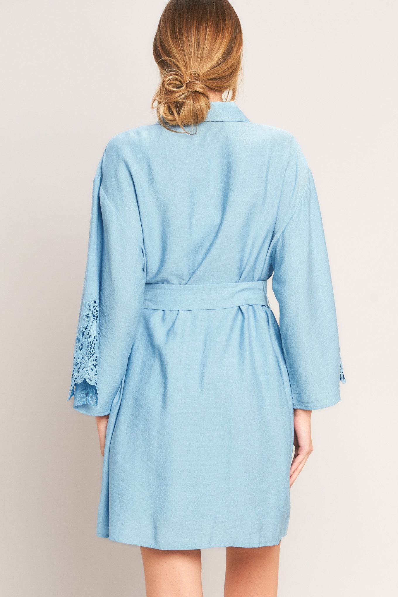 Light blue robe with lace details on a plain background