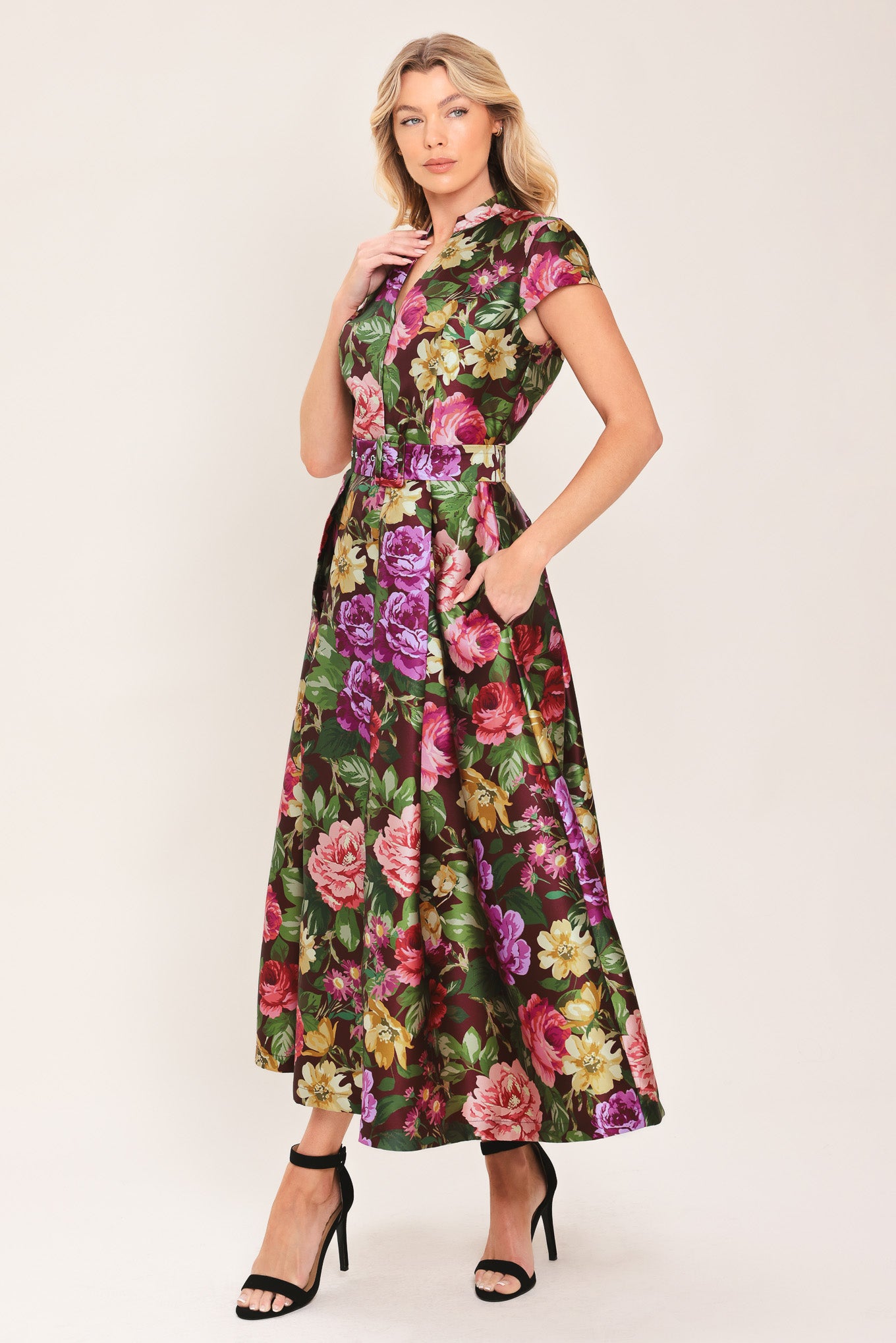 Woman wearing a floral printed woven midi dress featuring high collar with V front, short sleeve, self belt, full skirt and back zipper closure | Flying Tomato