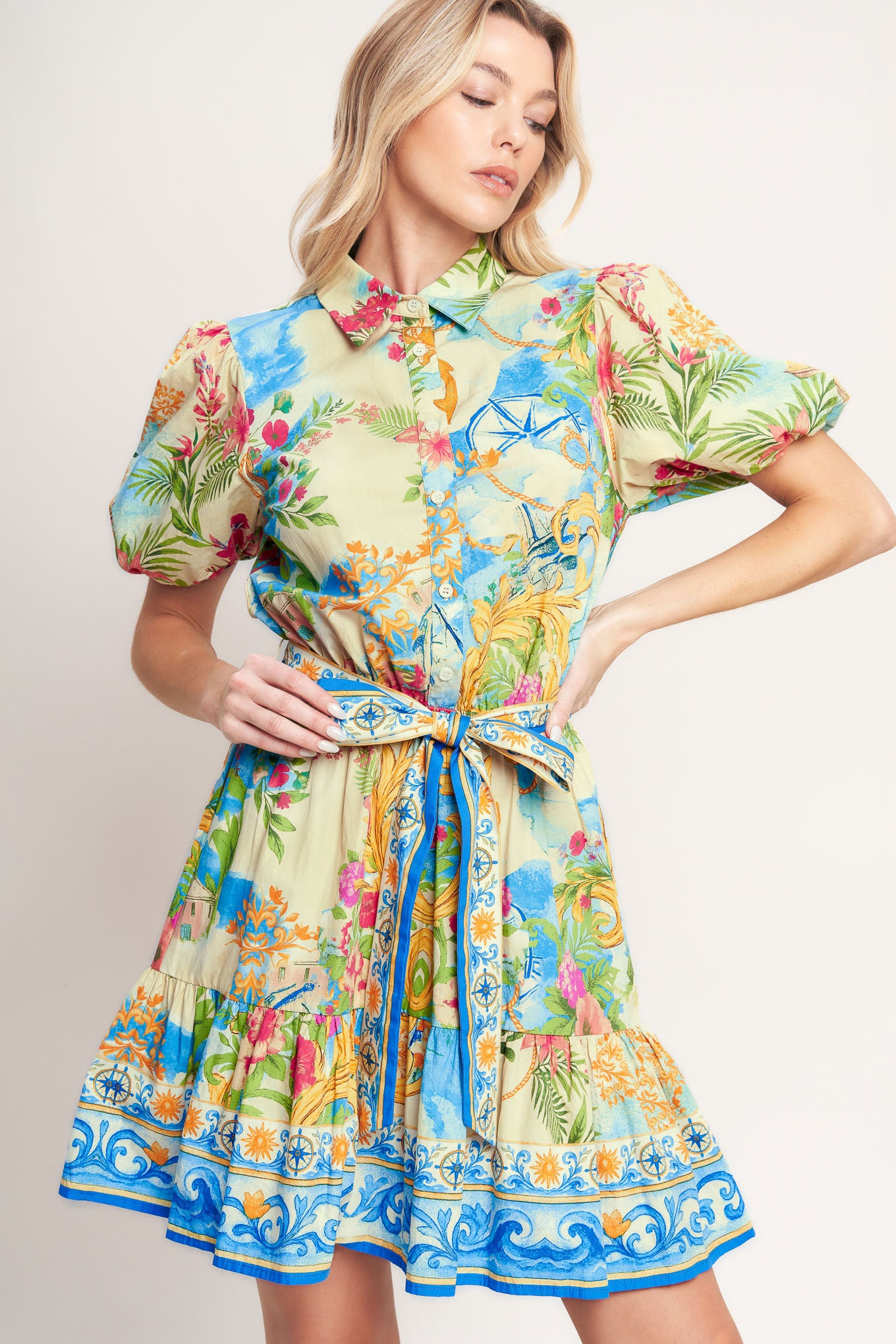 A printed woven mini dress featuring collar, short puff sleeve, front button down, elasticized waist with self sash tie and ruffle hem

Details:

Self: 100% Cotton

Size & Fit

-Model is 5`8" And Wearing Size Small
-Measurements Taken From Size Small
-Approx. Length: 36"