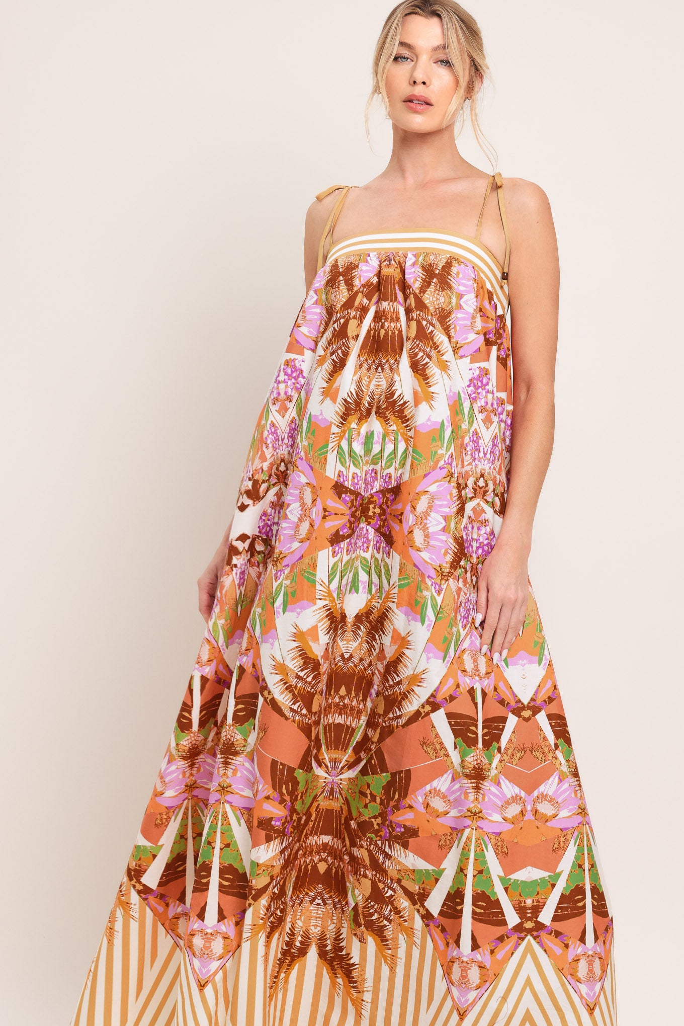 Woman wearing a maxi, patterned, multicolored orange and pink dress | Flying Tomato