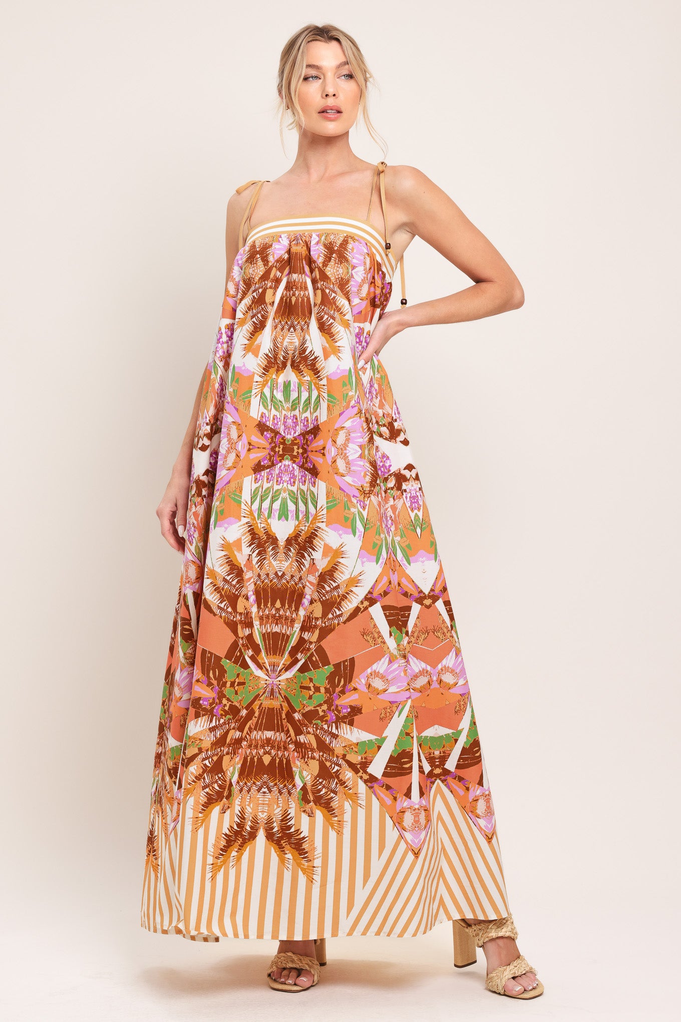 Woman wearing a maxi, patterned, multicolored orange and pink dress | Flying Tomato