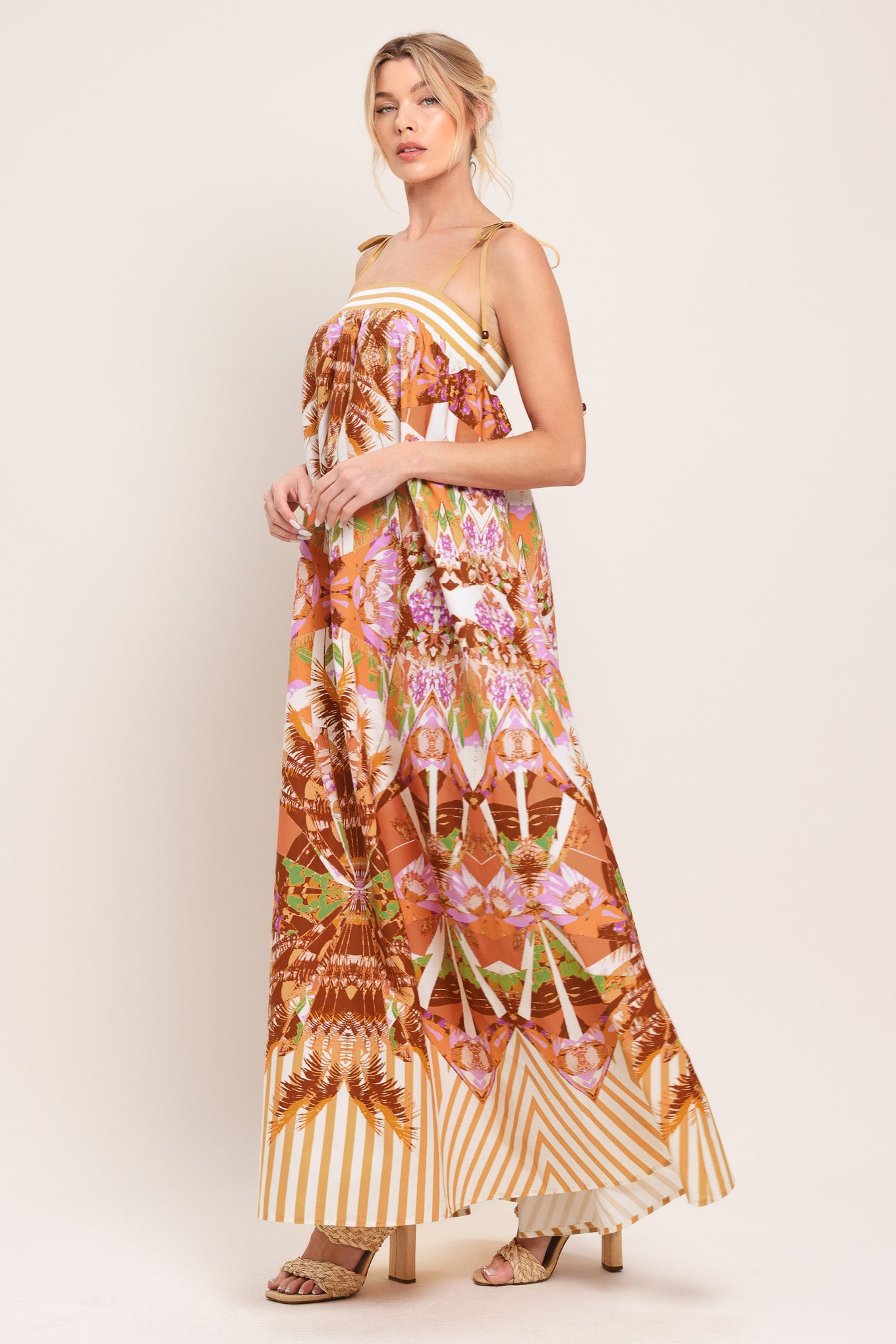 Woman wearing a maxi, patterned, multicolored orange and pink dress | Flying Tomato