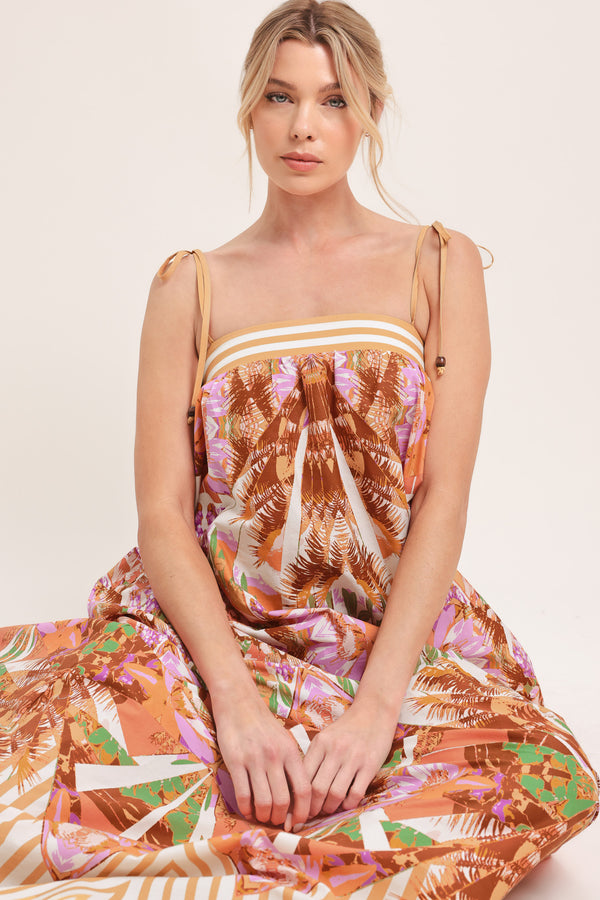 Woman wearing a maxi, patterned, multicolored orange and pink dress | Flying Tomato