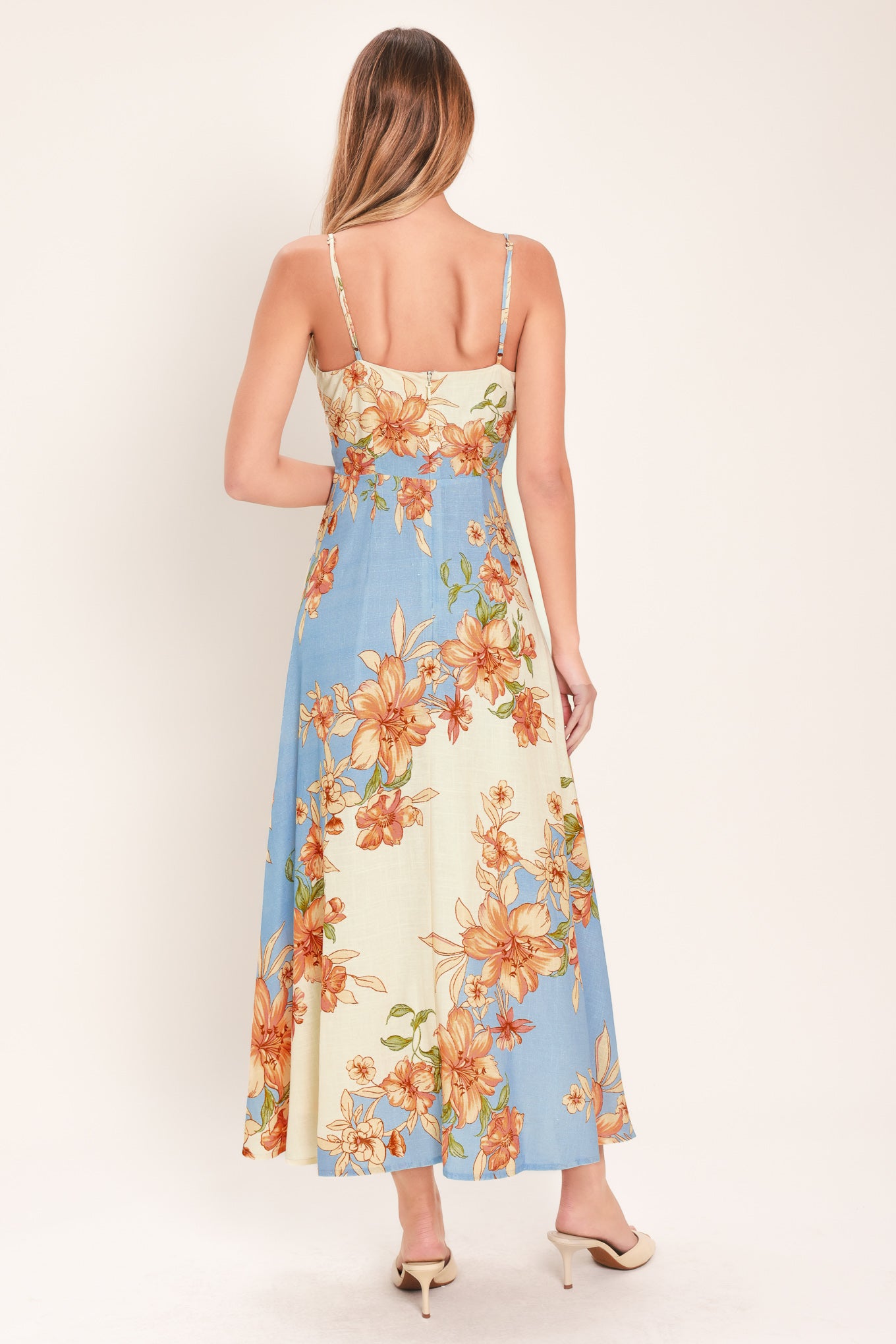 Woman wearing a blue and peach floral midi dress featuring straight neckline, straps, circle skirt and back zipper closure | Flying Tomato