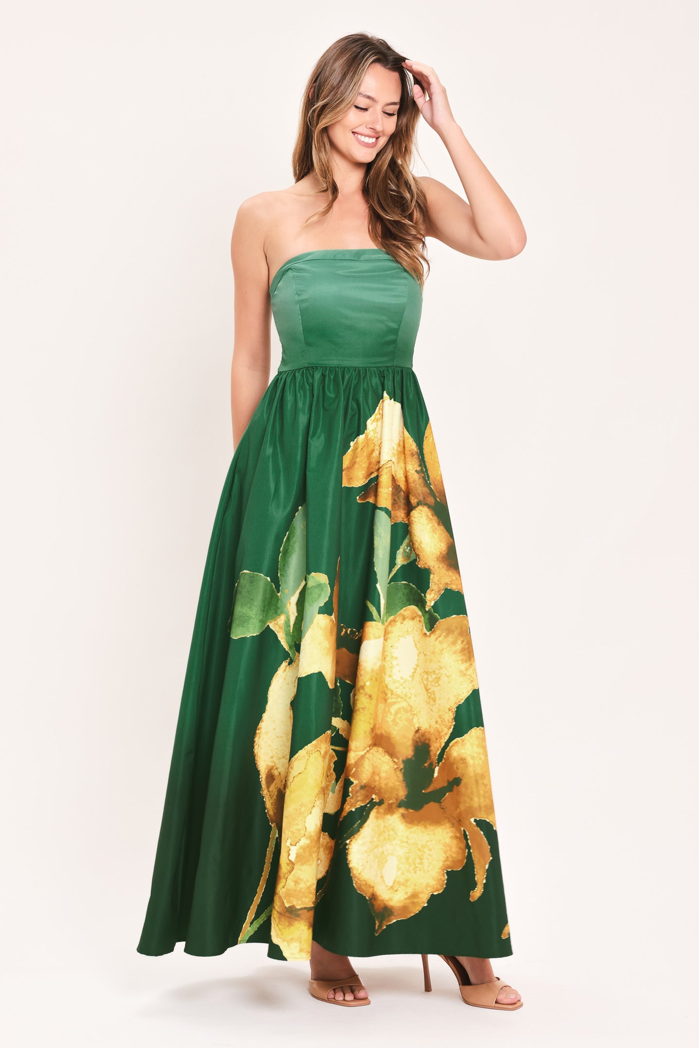 A woman modeling a strapless green maxi dress with a large yellow floral print on the skirt | Flying Tomato