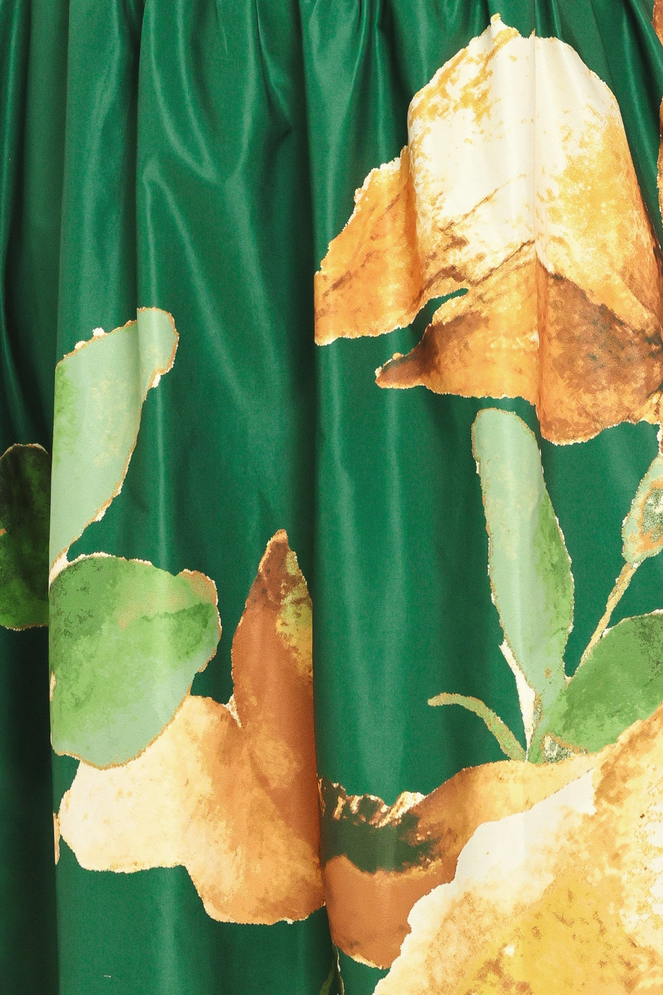 A woman modeling a strapless maxi dress with a green satin-like bodice and a large yellow floral print on a dark green skirt | Flying Tomato Curve