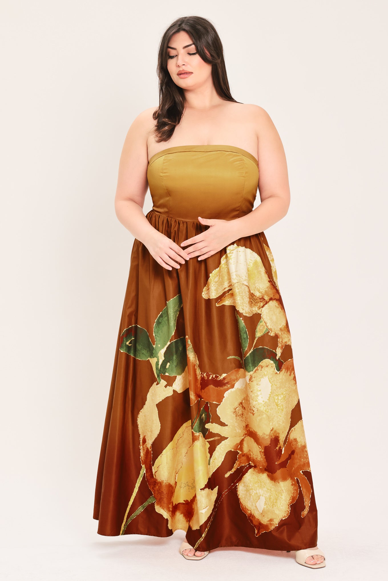 A woman modeling a strapless maxi dress with a mustard yellow top and a brown skirt featuring a large yellow and green floral print | Flying Tomato Curve