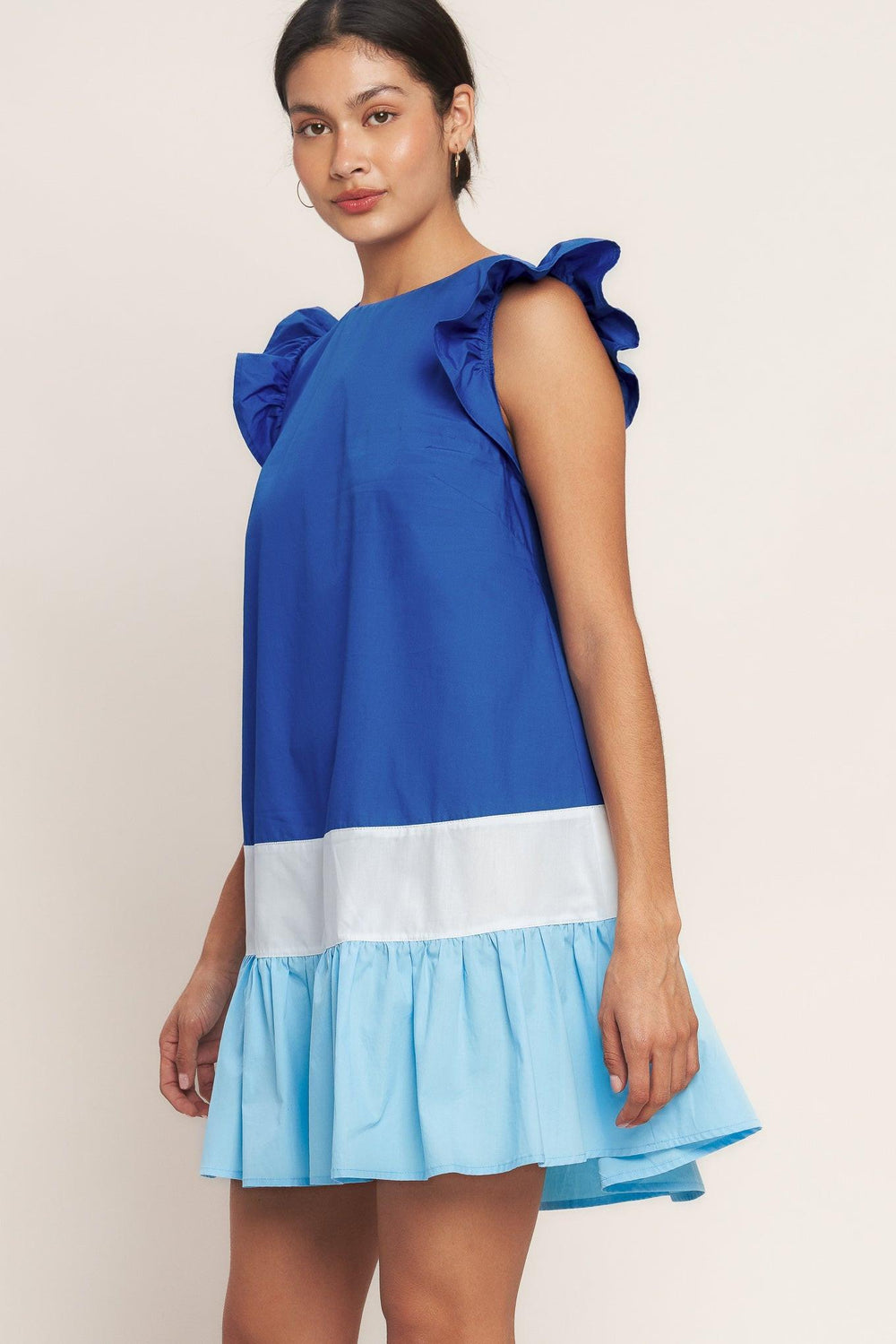
A woven color blocked mini dress featuring round neckline, ruffle sleeve, ruffle hem and back neck button closure

Details:

Self : 100% Cotton
Contrast : 100% Cotton

Size &amp; Fit

- Model is 5`8" And Wearing Size Small
- Measurements Taken From Size Small
- Approx. Length: 35"