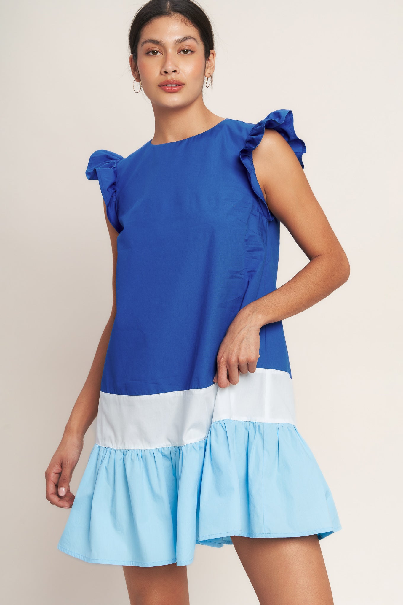 
A woven color blocked mini dress featuring round neckline, ruffle sleeve, ruffle hem and back neck button closure

Details:

Self : 100% Cotton
Contrast : 100% Cotton

Size &amp; Fit

- Model is 5`8" And Wearing Size Small
- Measurements Taken From Size Small
- Approx. Length: 35"